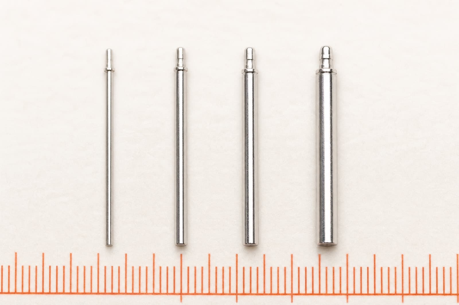 Four earring posts of different thicknesses laid side by side for comparison